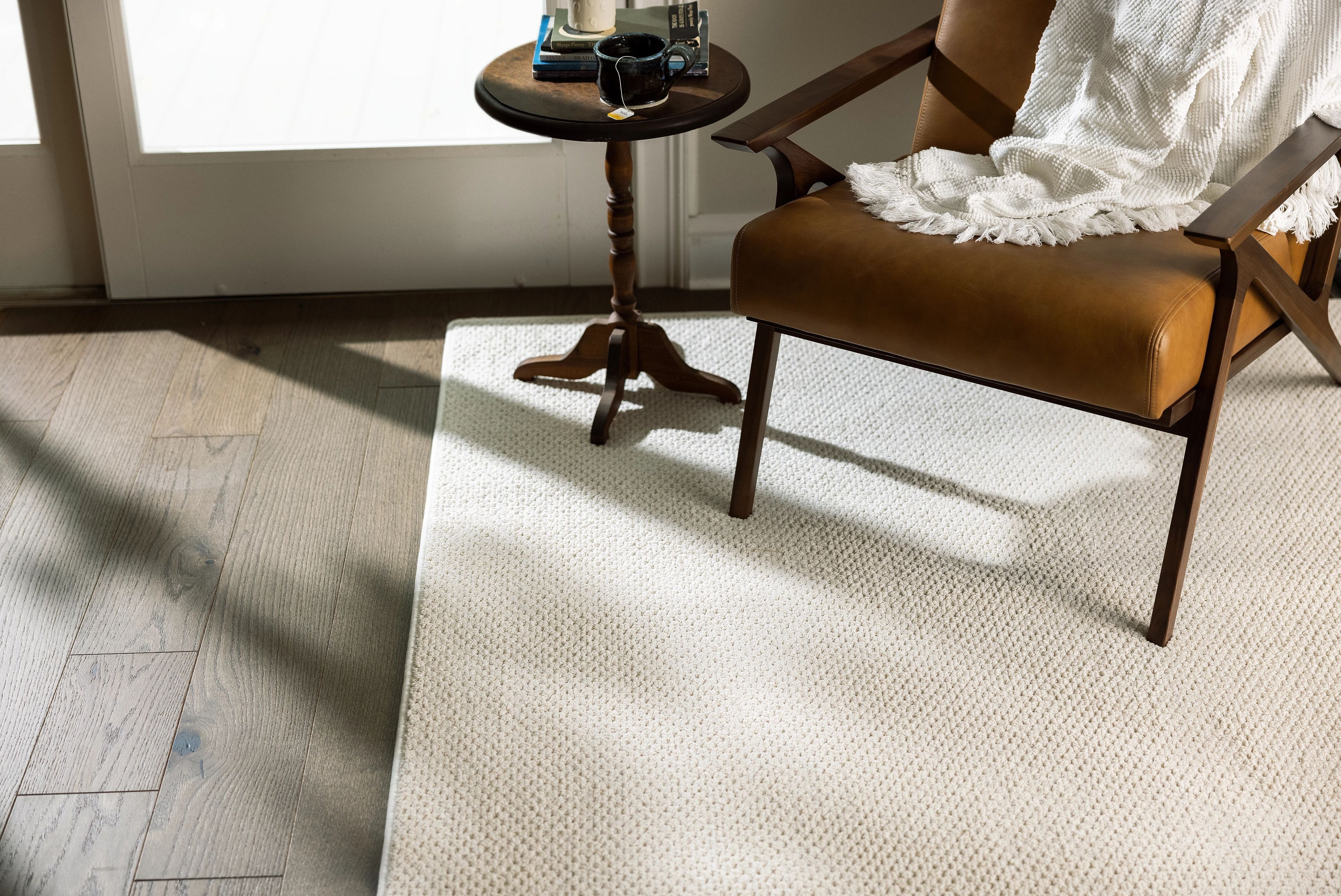Room with hardwood flooring and a beige area rug - Carpet binding services from Scott's Flooring in Barrie, ON