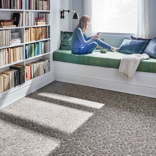 Person reading in the window in a room with patterned gray carpet from Scott's Flooring in Barrie, ON